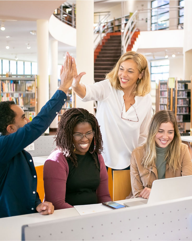 Cheerful-students-high-fiving-with-teacher